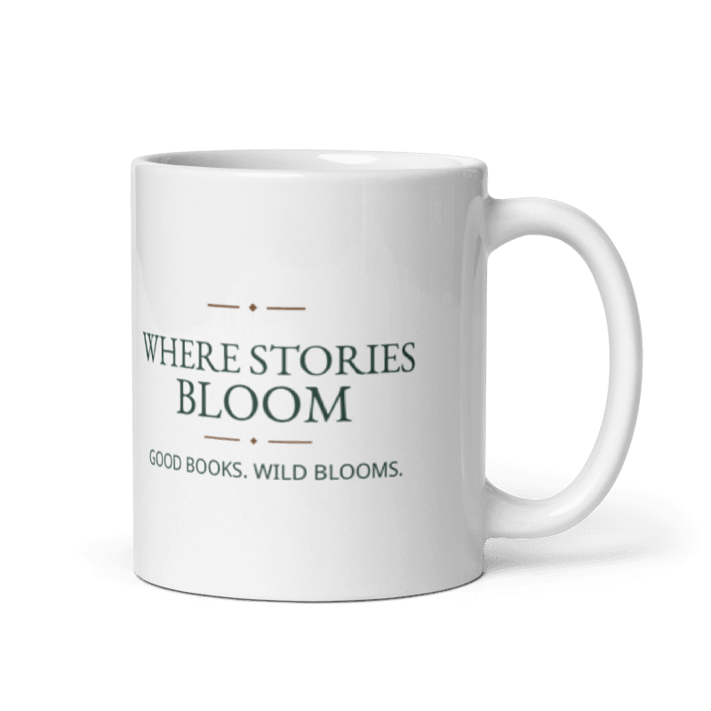 white 11 oz ceramic mug printed with Where Stories Bloom and Good Books. Wild Blooms. lettering, handle on the right