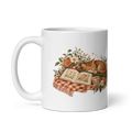 white glossy 11 oz ceramic mug with the A Sunday Well Read sleeping cat and open book illustration, handle on the left