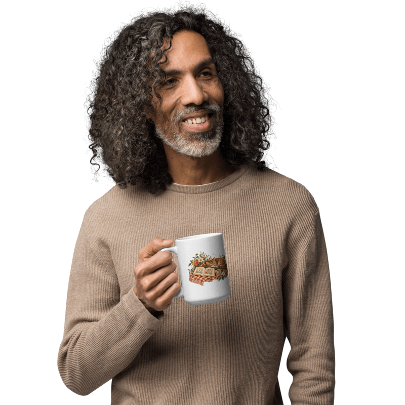 man in a beige sweater holding a white A Sunday Well Read mug with the illustration facing out