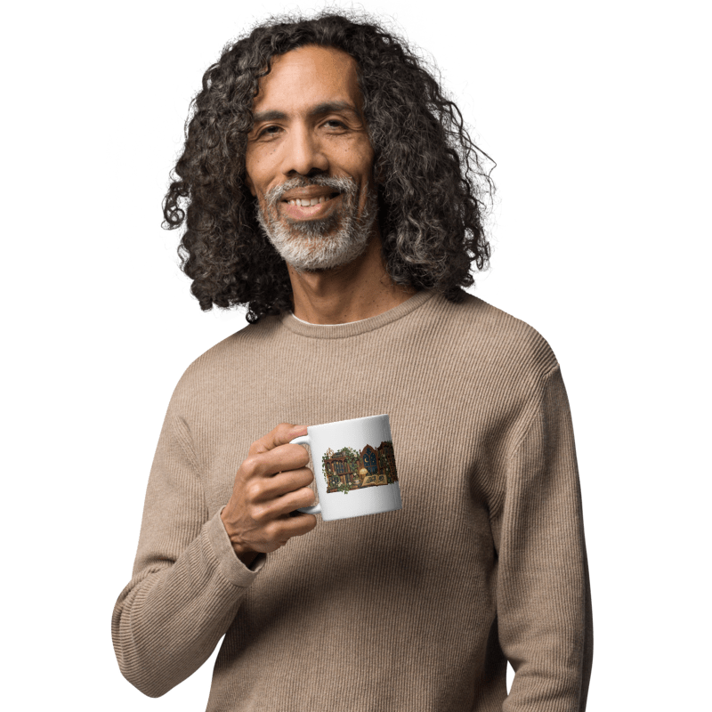 man in a beige sweater holding a white Lost in Lovely Chapters mug with the illustration facing out